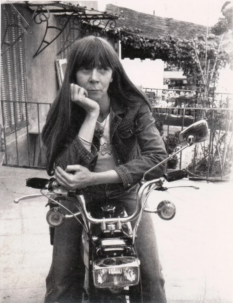 Black and white photo of a young woman on a motorbike