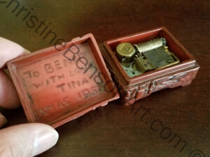 A small Carved Music Box open showing carved message: "To Benny with Love Tina - Xmas 1956"