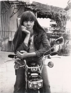 Black and white photo of a young woman on a motorbike